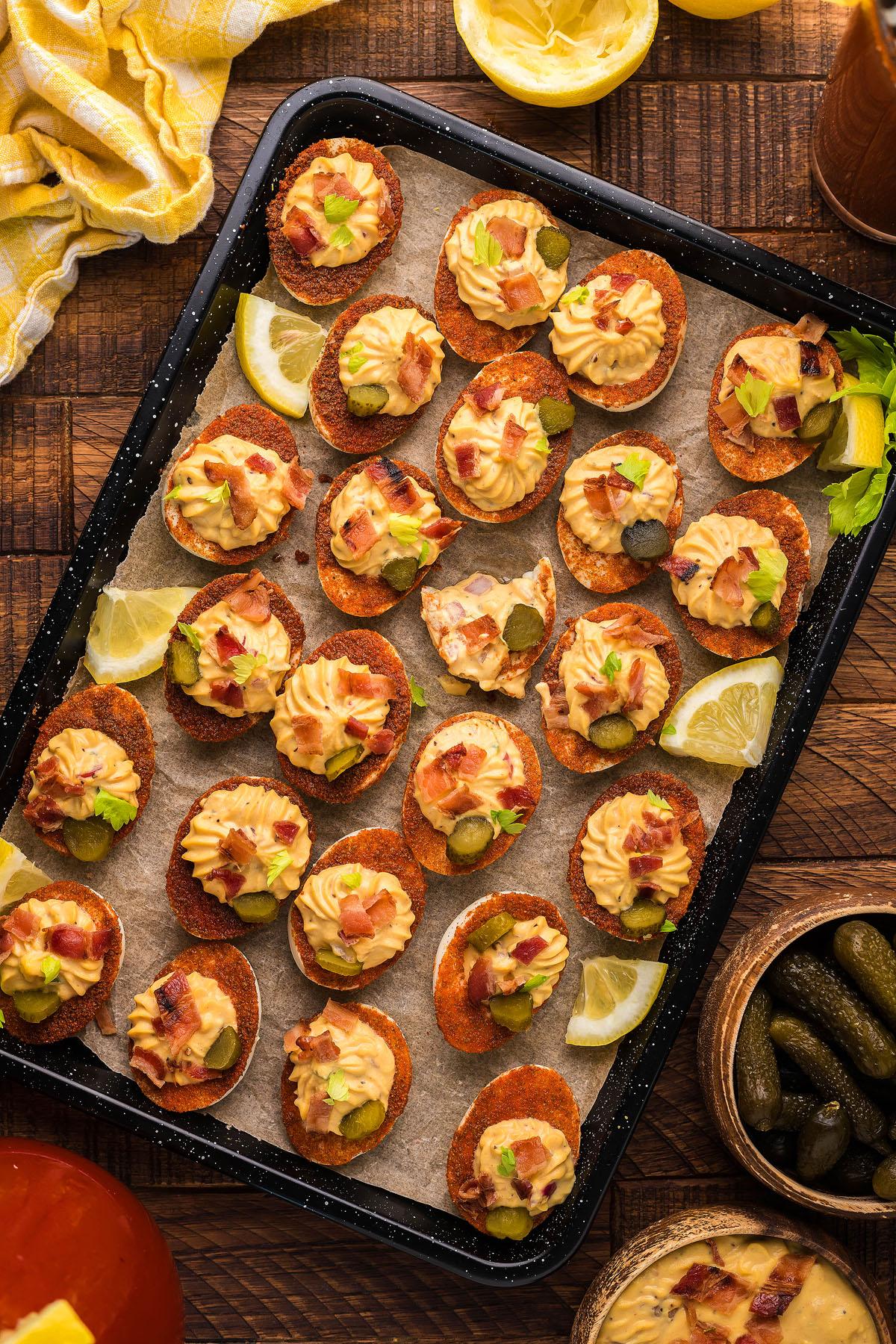 Bloody Mary deviled eggs on a baking sheet