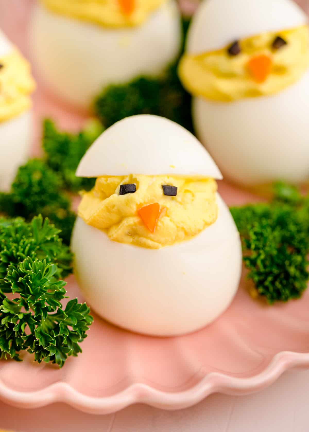 Deviled egg decorated like a little chick with eyes and a nose