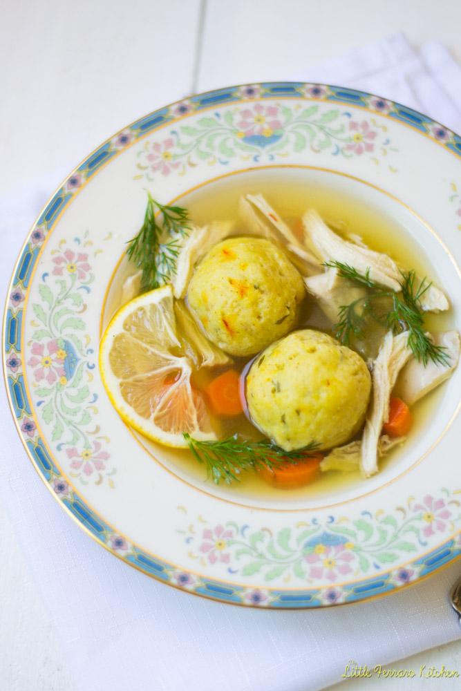 Lemon Saffron Matzo Ball Soup. Soup in a china bowl on a china plate. 