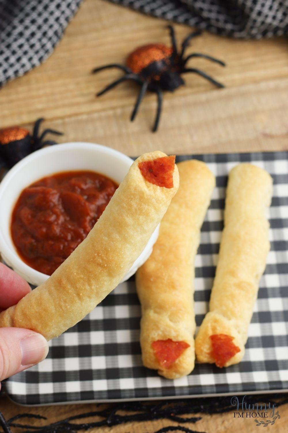 Witch finger breadsticks made with crescent rolls with pepperoni as the finger nails