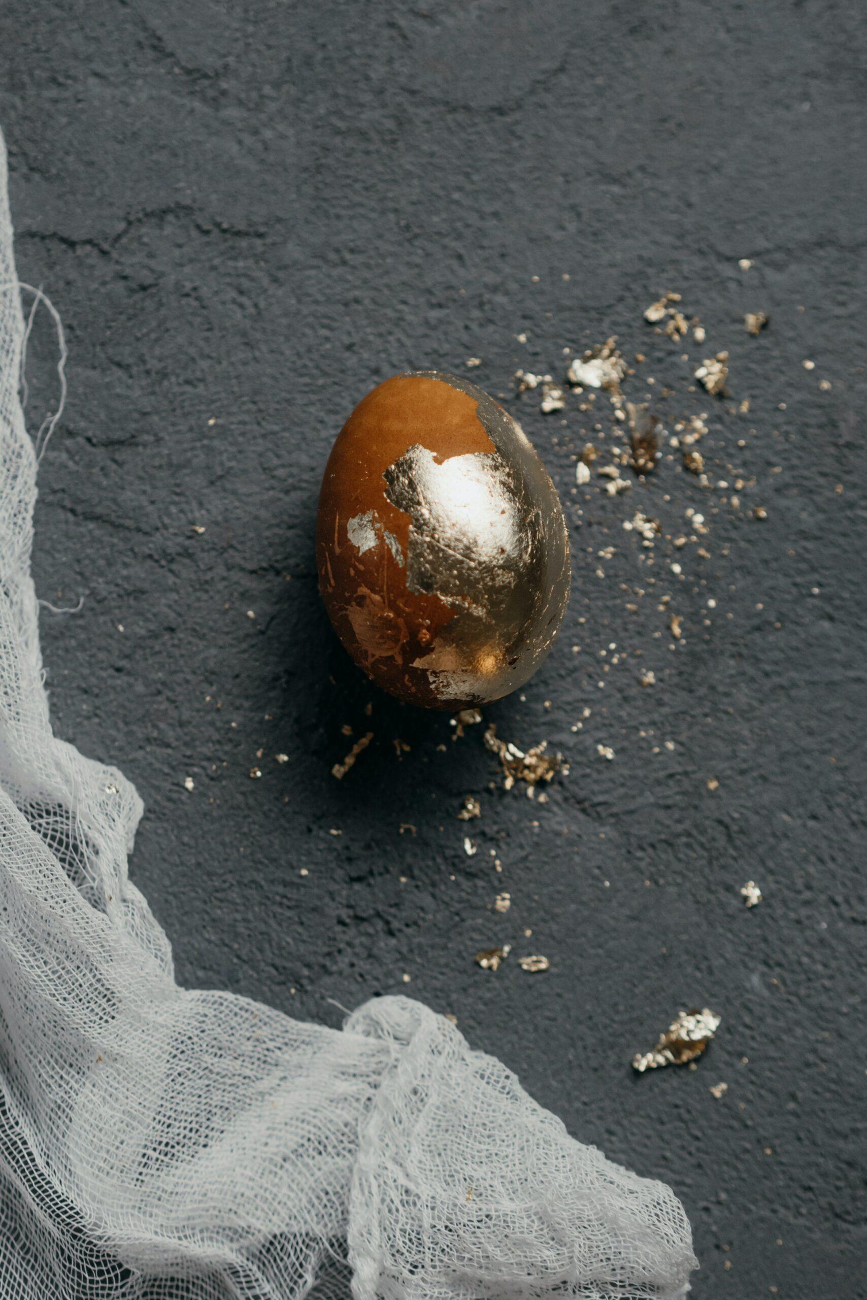 An egg that is painted brown and has gold flecks on it