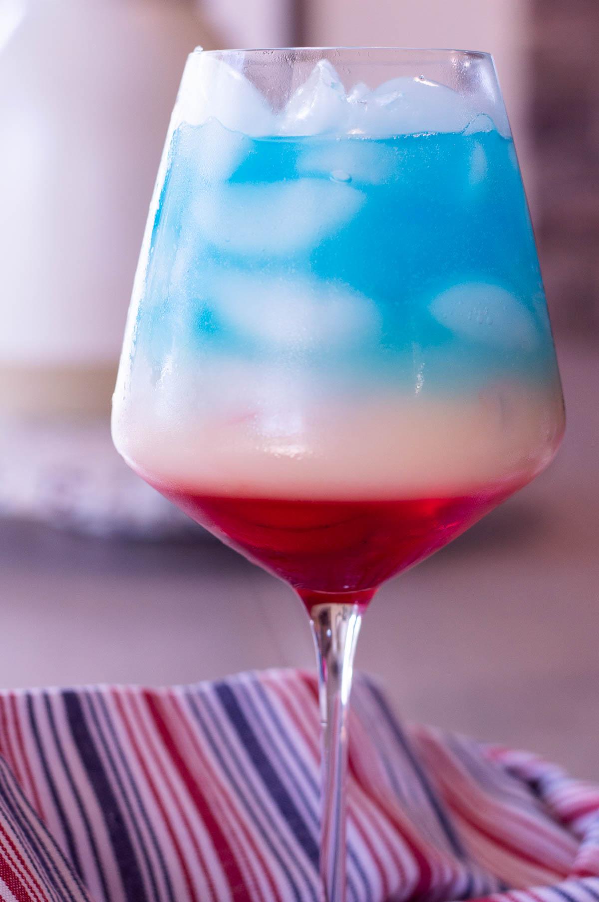 layered 4th of July mocktail red, white and blue in a glass