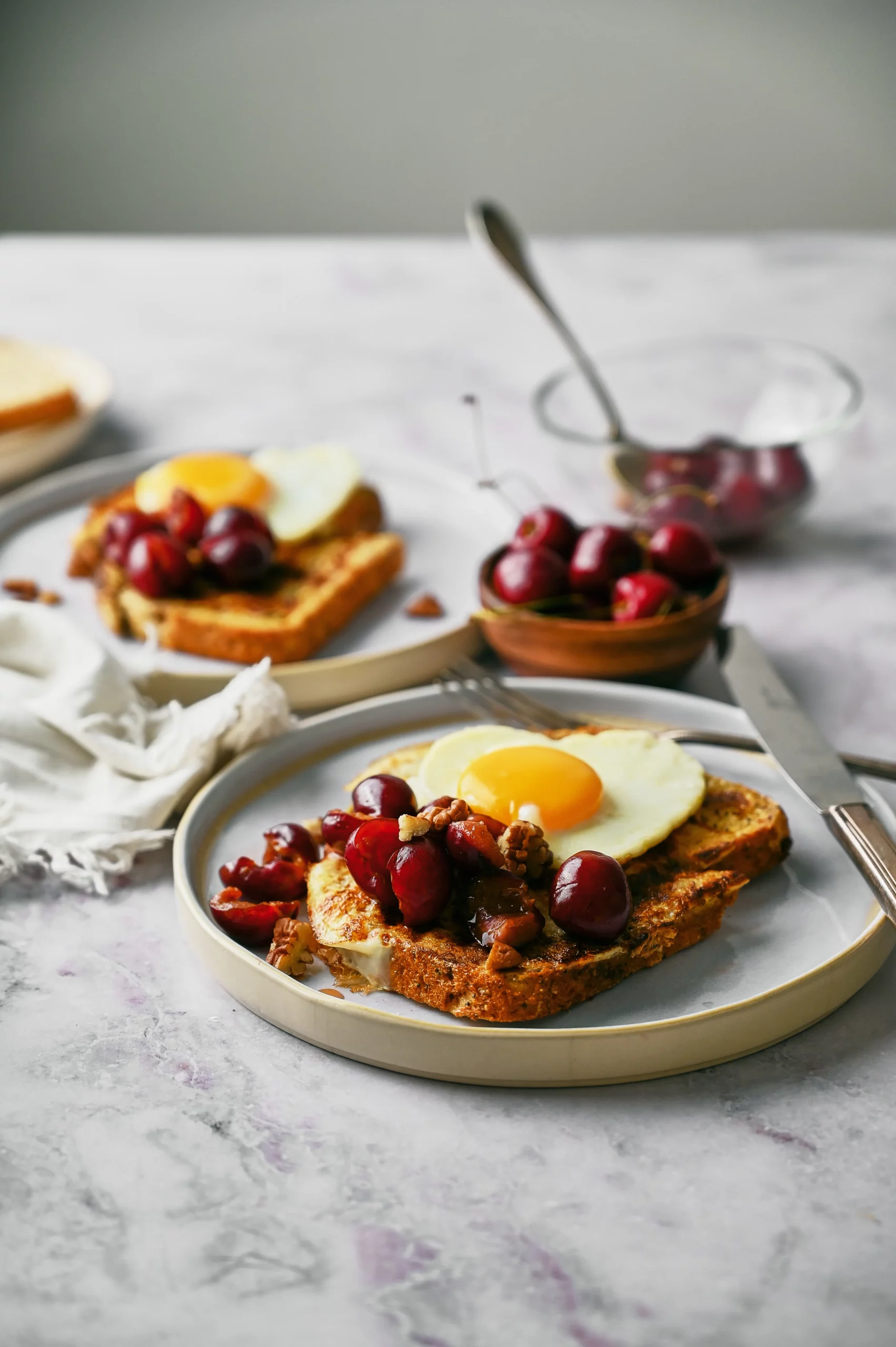 French toast with an egg on top with berries and nuts