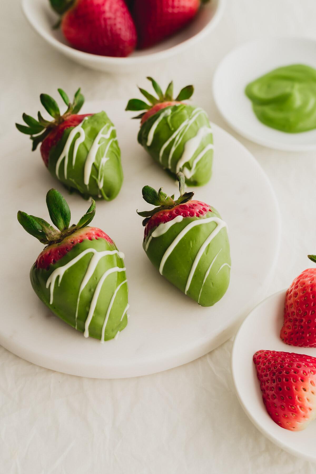 Matcha chocolate covered strawberries with a white chocolate drizzle