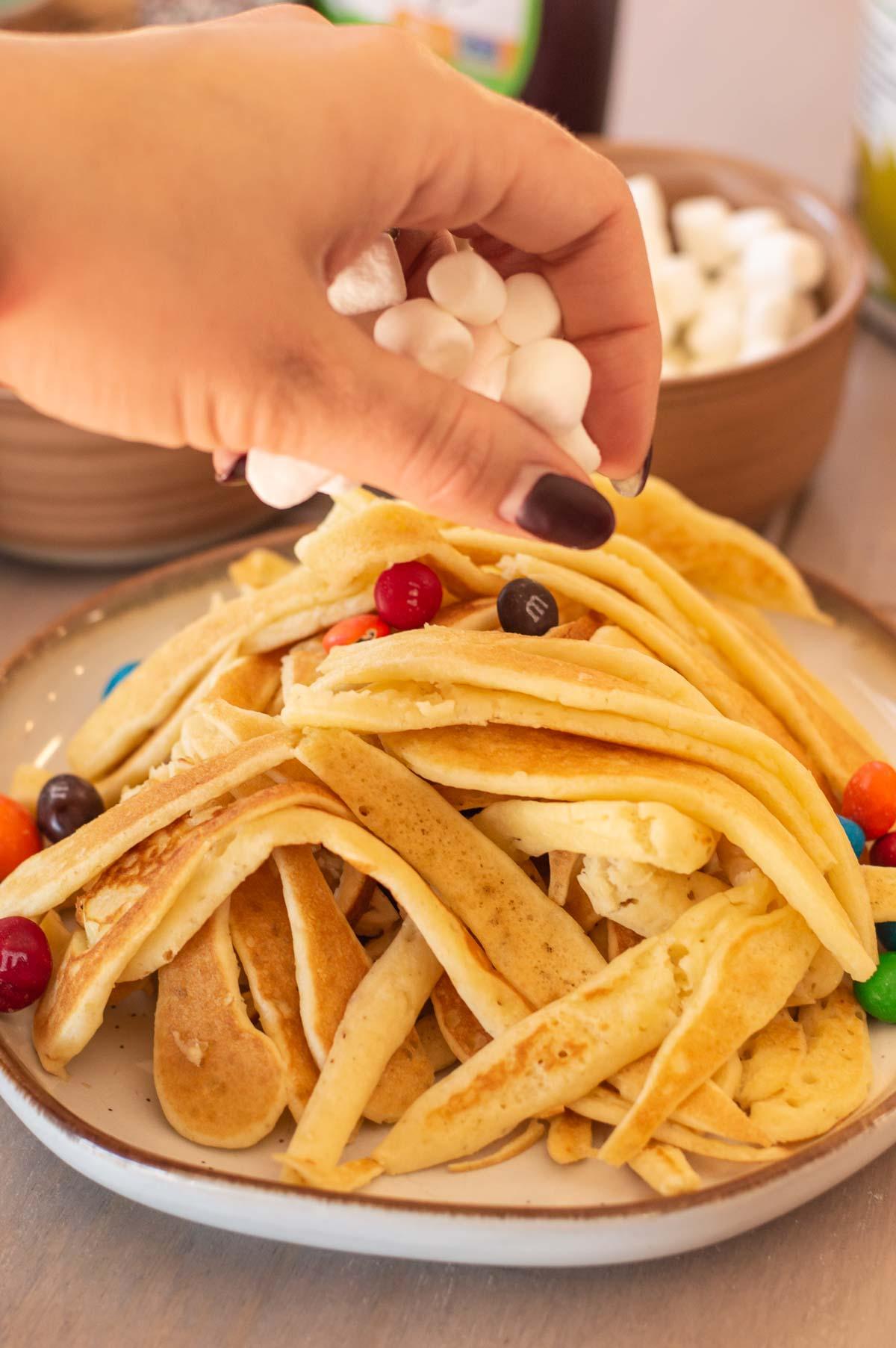 Pancake Spaghetti (Elf Style) being made with marshmallows on top