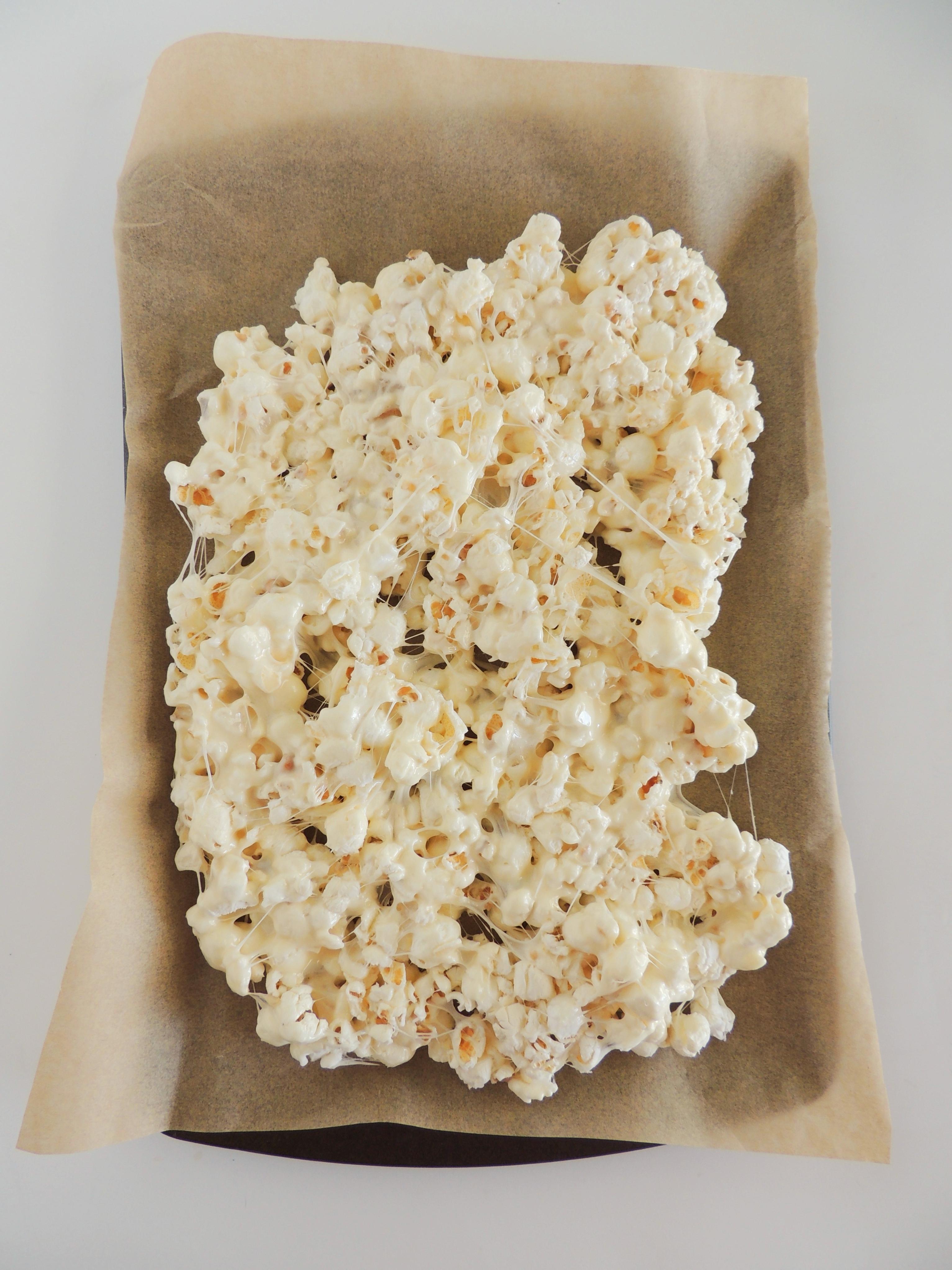 Easy Christmas Popcorn on a parchment lined baking sheet
