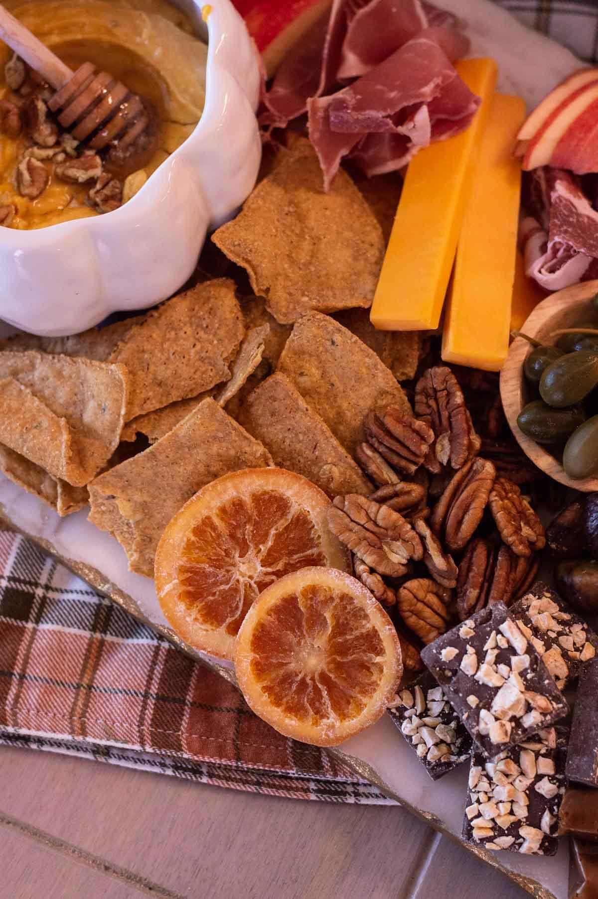 Fall Charcuterie Board with candied oranges and nuts on a board