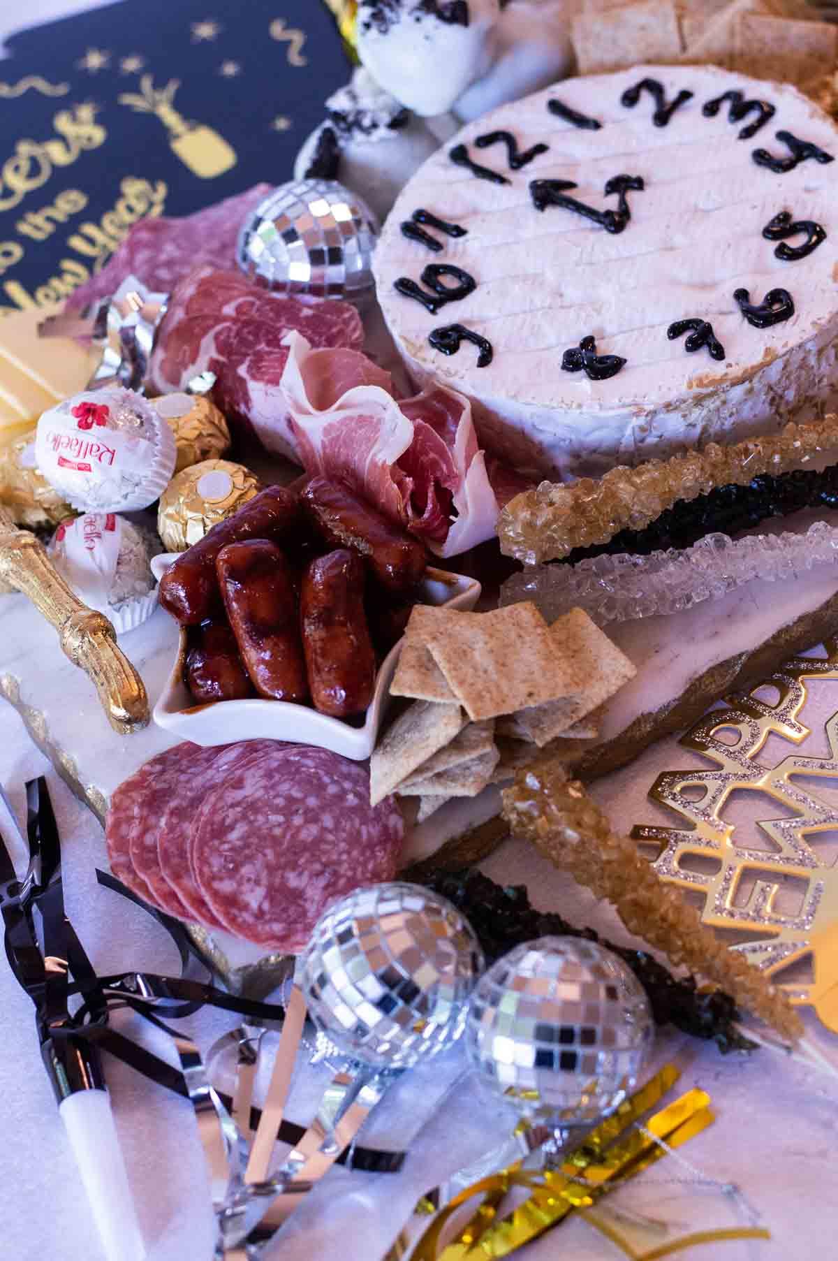 New Year's Eve Charcuterie Board with treats and a brie clock