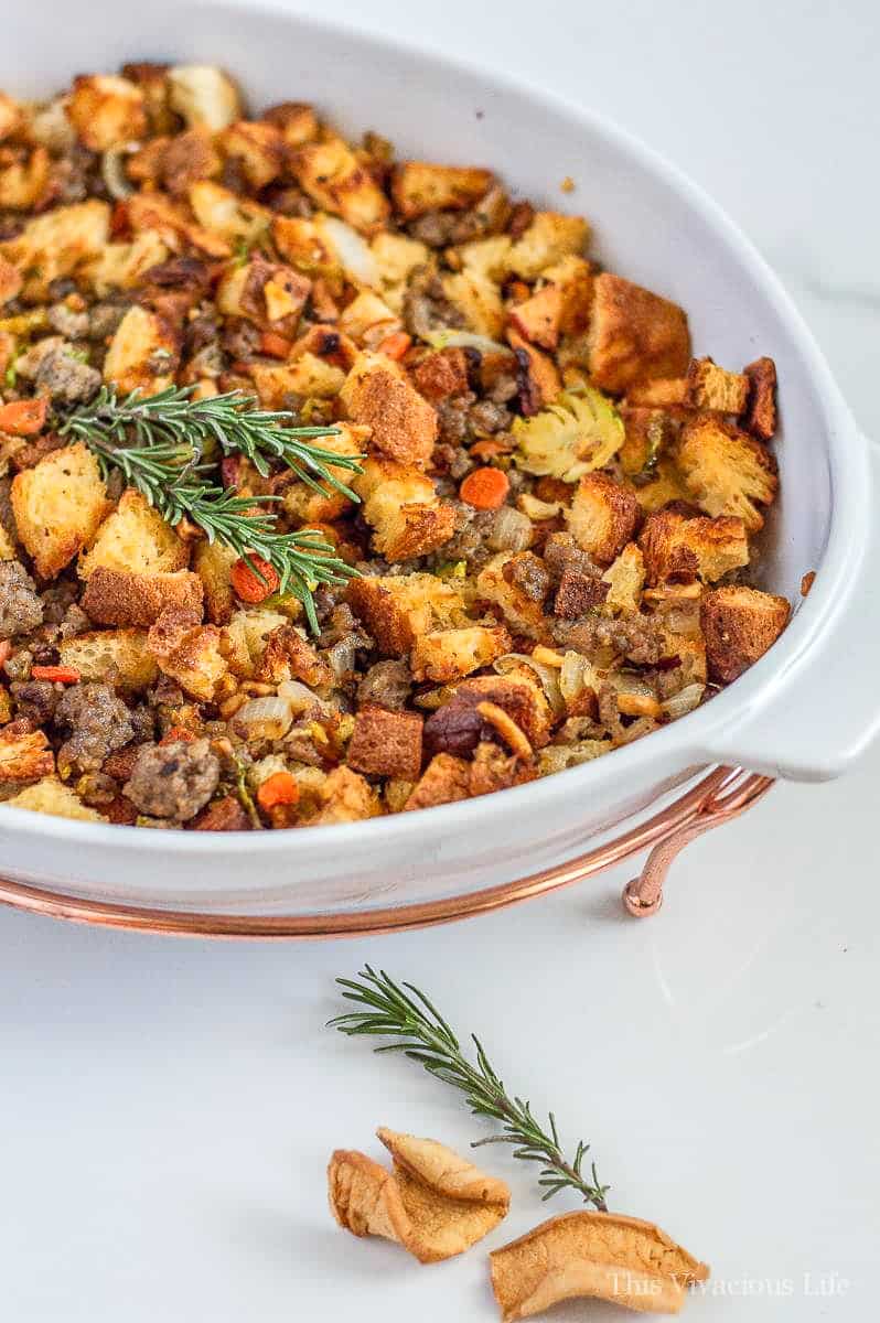 Traditional thanksgiving dressing recipe with apples and sausage in a casserole dish 