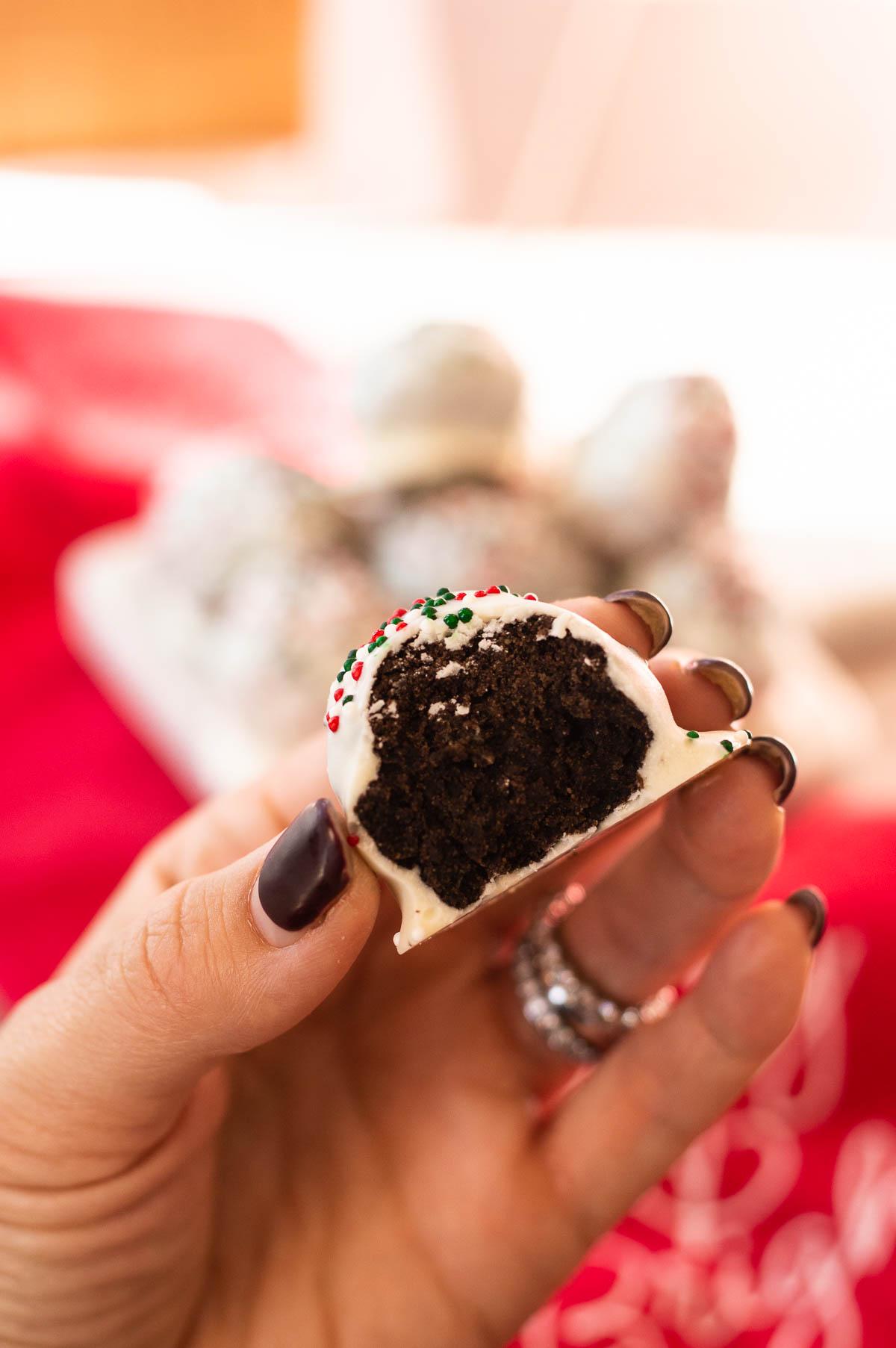 Christmas Oreo Truffles in a hand with bite taken out