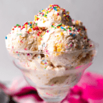 square image of many scoops of birthday cake ice cream with rainbow sprinkles in a tall, glass dish