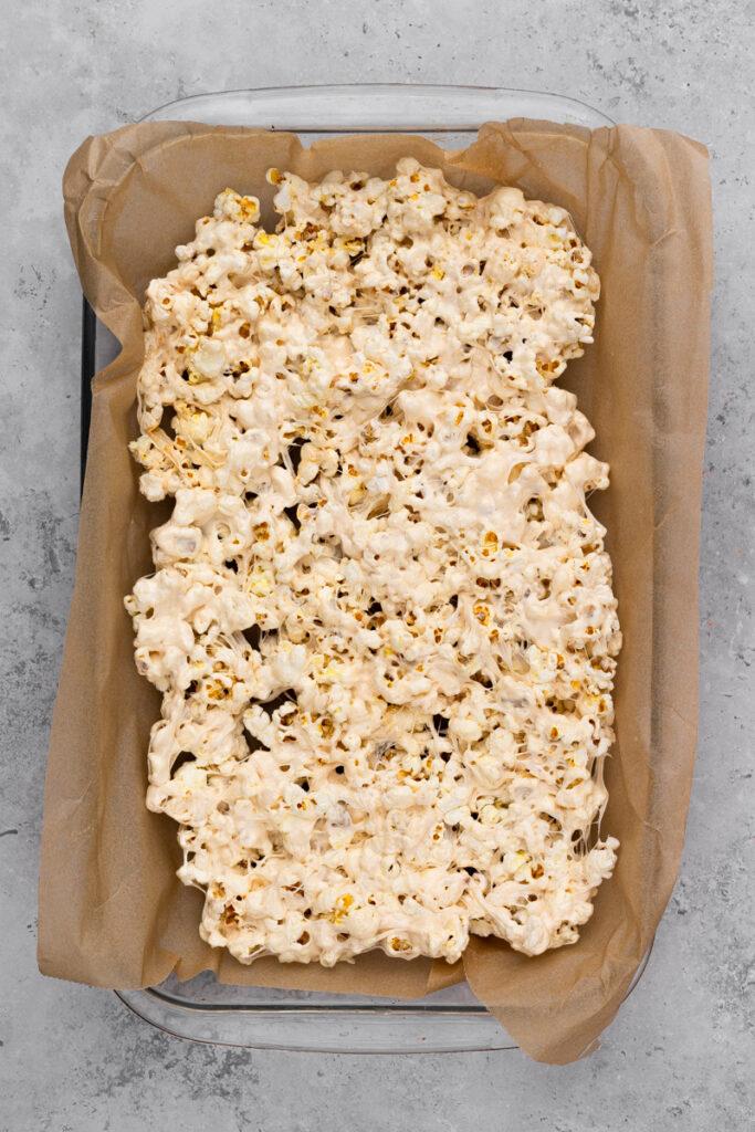popcorn topped with white chocolate lined on brown parchment paper